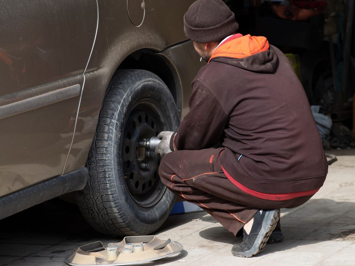 Mechaniker wechselt ein Rad an einem Fahrzeug in der Werkstatt